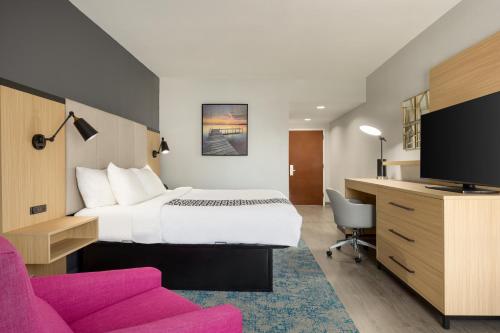 une chambre d'hôtel avec un lit, un bureau et une télévision dans l'établissement La Quinta Inn & Suites by Wyndham Selma/Smithfield I-95, à Selma