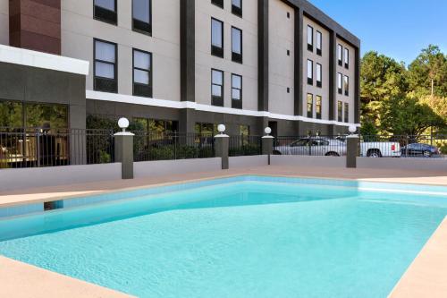 une grande piscine devant un immeuble dans l'établissement La Quinta Inn & Suites by Wyndham Selma/Smithfield I-95, à Selma
