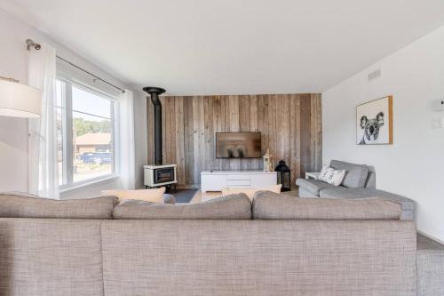 sala de estar con sofá grande y TV en INITIAL - KOALA - Mont-Sainte-Anne, en Beaupré
