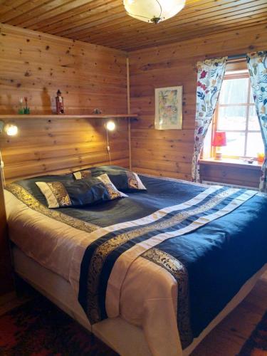 Säng eller sängar i ett rum på Mysig timmerstuga vid sjön Björken