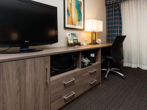 a hotel room with a television and a desk with a chair at Holiday Inn Des Moines-Downtown-Mercy Campus by IHG in Des Moines