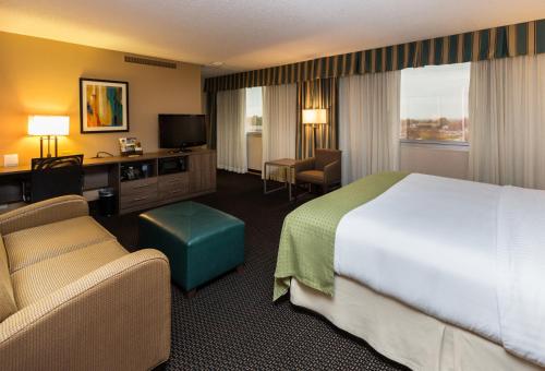a hotel room with a bed and a desk and chair at Holiday Inn Des Moines-Downtown-Mercy Campus by IHG in Des Moines