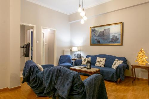 a living room with a blue couch and a table at Apartment overlooking the old bridge in Chalkida