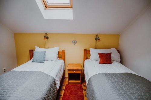 two beds in a small room with two pillows at Pension Tofalvi in Harghita-Băi