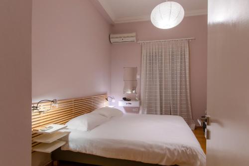 a bedroom with a white bed and a window at Apartment overlooking the old bridge in Chalkida