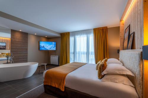 a hotel room with a bed and a bath tub at ILY Hotels & Spa La Rosiere in La Rosière