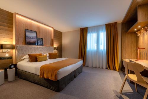 a hotel room with a bed and a desk at ILY Hotels & Spa La Rosiere in La Rosière