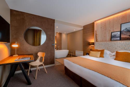 a hotel room with a large bed and a bath tub at ILY Hotels & Spa La Rosiere in La Rosière