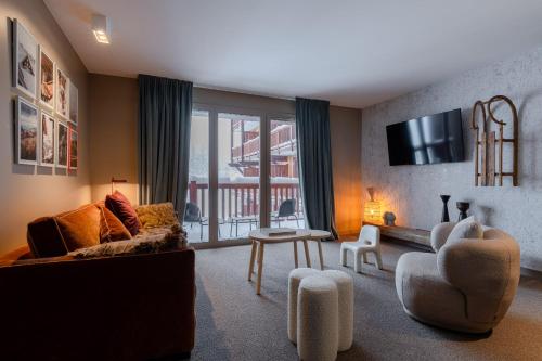 a living room with a couch and chairs and a tv at ILY Hotels & Spa La Rosiere in La Rosière
