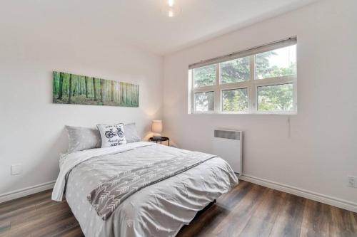 Un dormitorio blanco con una cama y dos ventanas. en INITIAL - La Charmante - MSA - Piscine privée, en Saint-Férréol-les-Neiges