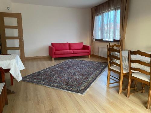 a living room with a red couch and a rug at Apartment at a Resort by the Black Sea in Sakarya