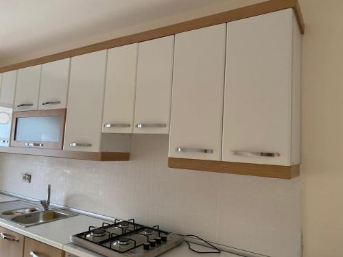 cocina con armarios blancos y fogones en Apartment at a Resort by the Black Sea en Sakarya