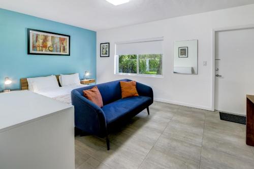 a living room with a blue couch and a bed at Cottages El Portal in Miami