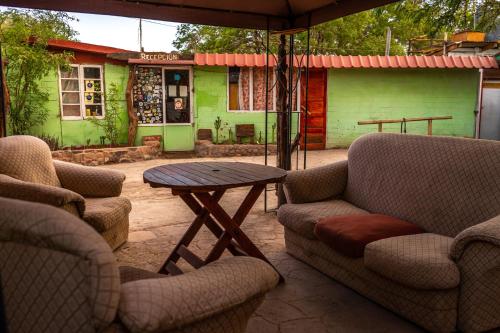 a patio with two chairs and a table with an umbrella at La Casa del Sol Naciente in San Pedro de Atacama