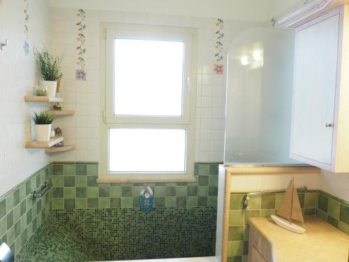 a bathroom with a shower with a window and a sink at Attico Sulla Spiaggia in Viareggio