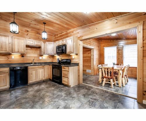 a kitchen with wooden cabinets and a table with chairs at City Hideaway - Hot Tub, Fireplace, Grill in Gatlinburg