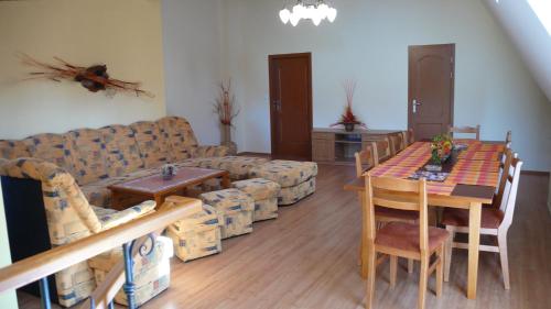 a living room with a couch and a table and chairs at Penzion Padrtův mlýn in Třebíč