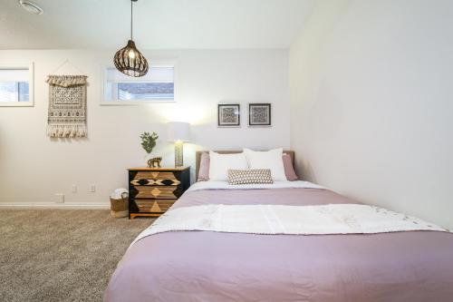 a white bedroom with a large bed and a lamp at Bali Style Home - King Bed - Fireplace - Jacuzzi - Fast Wi-Fi - Free Netflix & Garage Parking in Edmonton
