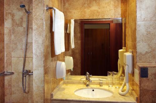 ein Bad mit einem Waschbecken und einer Dusche in der Unterkunft Bella Vista Beach Club - All Inclusive in Sinemorets