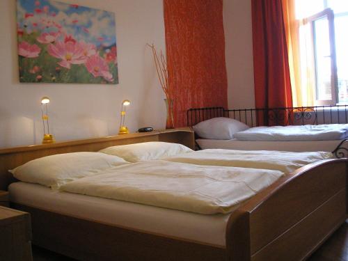 ブラチスラヴァにあるApartment Riverside - River Viewの壁に絵画が飾られたベッドルーム1室(ベッド2台付)
