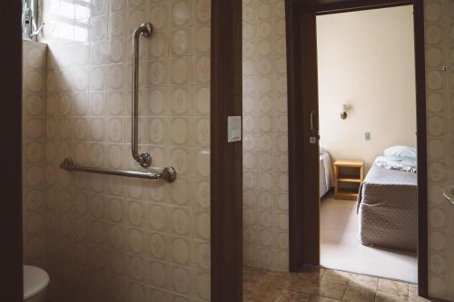 uma casa de banho com uma cabina de duche ao nível do chão e um WC. em Pousada Betânia em Curitiba