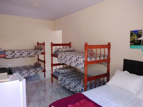a room with three bunk beds and a bed at Pousada Gotam in Caraguatatuba