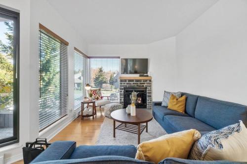 a living room with a blue couch and a fireplace at INITIAL - SOMMET - Mont-Sainte-Anne in Beaupré