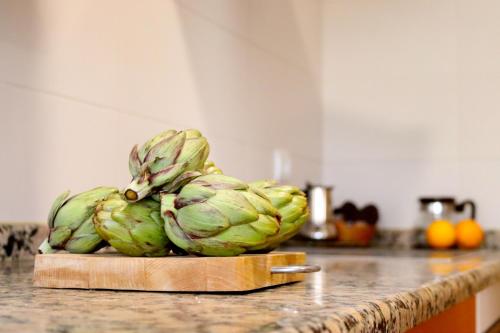 una pila de alcachofas en una tabla de cortar en un mostrador de cocina en Alojamiento Rural Ribaforada en Ribaforada