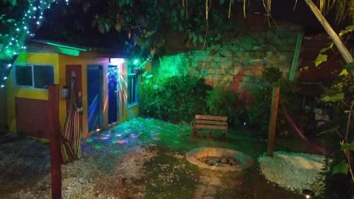 a house with green lights in a yard with a bench at Hostal Macondo Inn in Carmen de Viboral