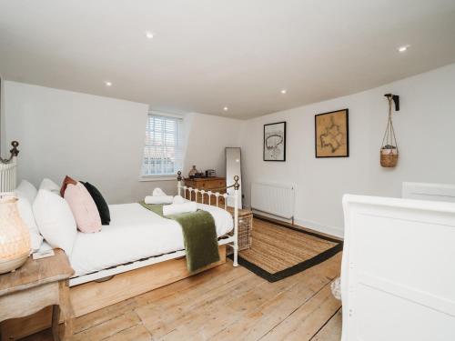 a bedroom with a bed with white walls and wooden floors at Pass The Keys Stylish 2 Bed Eco Flat in the heart of Bath in Bath