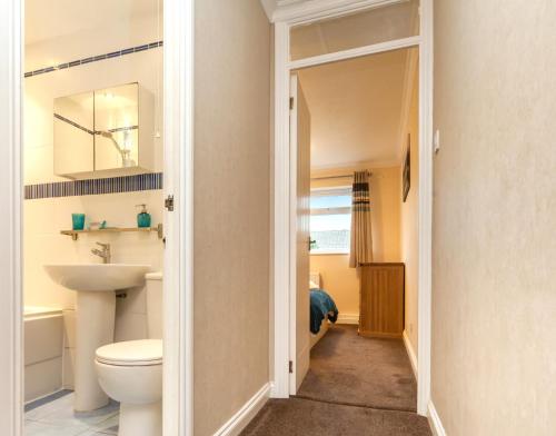 a bathroom with a toilet and a sink at Sawyers Lodge in Burgess Hill