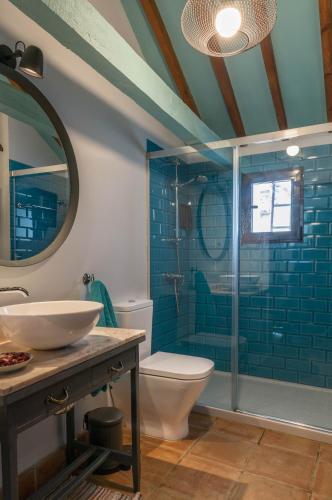 a bathroom with a toilet and a sink and a mirror at Casa Cuqui in Orgaz
