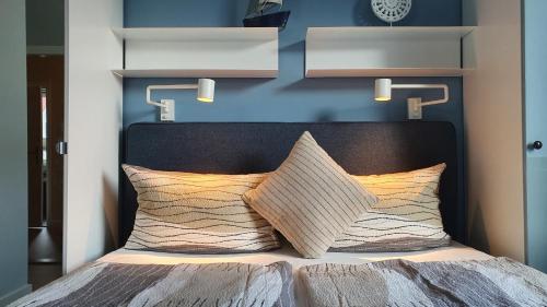 a bed with a black headboard and two pillows at seemoi in Norderney