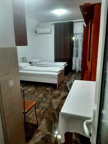 a room with a bed and a table and a chair at CASA ARDELEANULUI in Satu Mare