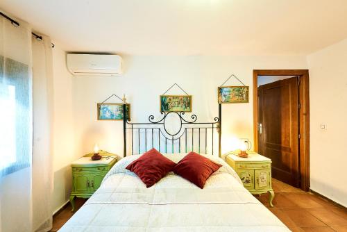 ein Schlafzimmer mit einem weißen Bett und zwei Nachttischen in der Unterkunft Vivienda Turística La Huerta in Guadalcanal