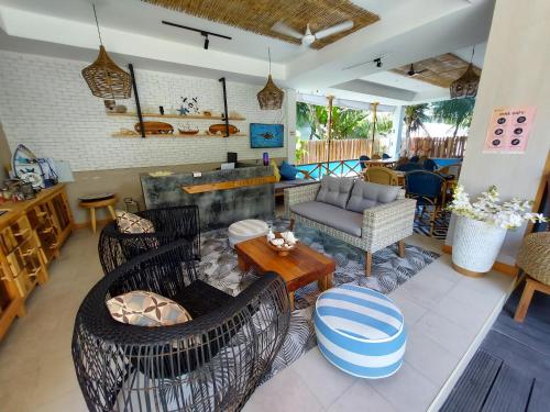 ein Wohnzimmer mit Stühlen, einem Sofa und einem Tisch in der Unterkunft Palms Retreat in Fulhadhoo