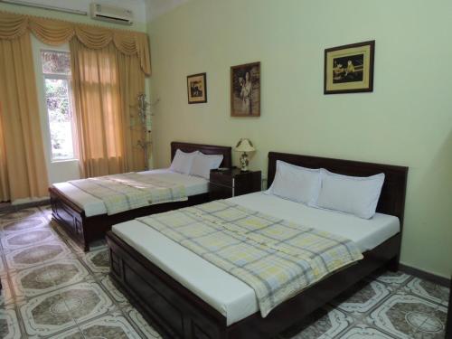 a bedroom with two beds and a window at Hai Trang Hotel in Ha Long