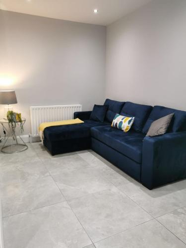 a blue couch in a living room with a bed at Modern 3-Bed Apartment in Magherafelt Sleeps 8 in Magherafelt