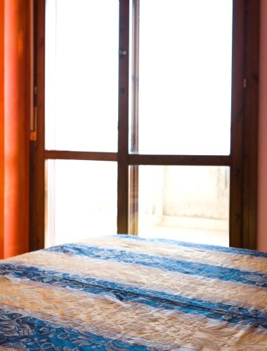 a bed in a room with an open window at Residence Le Terrazze Sul Mare in San Mauro a Mare