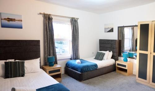 a bedroom with two beds and a window at Windham ApartHotel by Serviced Living Liverpool in Litherland