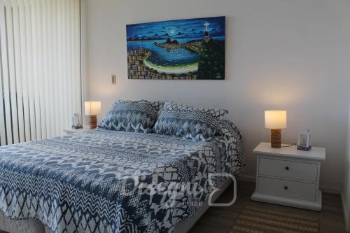 1 dormitorio con 1 cama y una pintura en la pared en Departamento Av del Mar La Serena Disegni 01, en Coquimbo