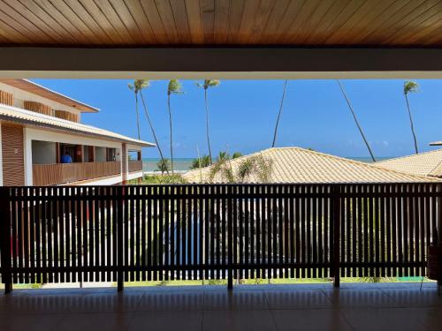 a balcony with a black fence and palm trees at Apto novo Imperia Lounge pé-na-areia Itacimirim in Itacimirim