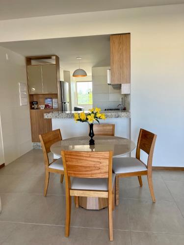 a kitchen and dining room with a table and chairs at Apto novo Imperia Lounge pé-na-areia Itacimirim in Itacimirim
