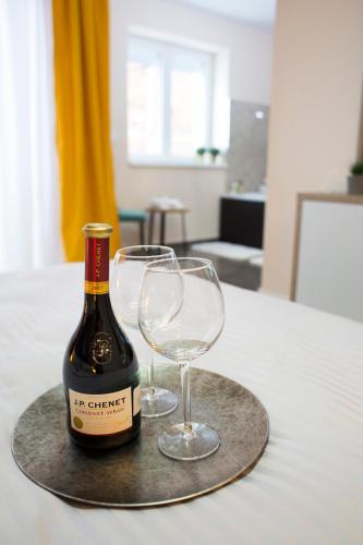 a bottle of wine and two wine glasses on a table at Galaxy Apartments in Belgrade