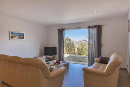 a living room with two couches and a television at Domaine Ghjulia in Patrimonio