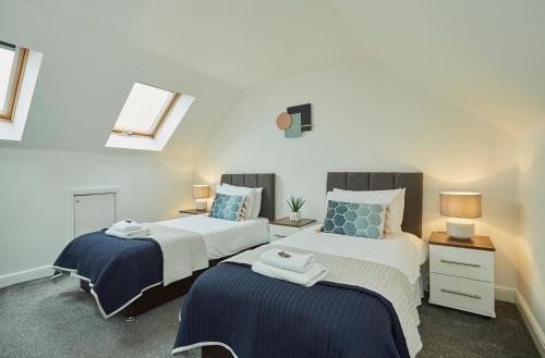 2 nebeneinander sitzende Betten in einem Schlafzimmer in der Unterkunft Brackenhill Lodge Halifax in Queensbury
