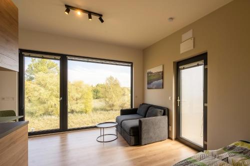 a living room with a chair and a large window at Na Zeleném statku in Rašovice