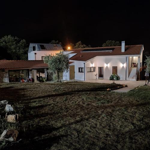 a white house at night with a yard at Poço e Meio - Padel & Pool in Santiago da Guarda