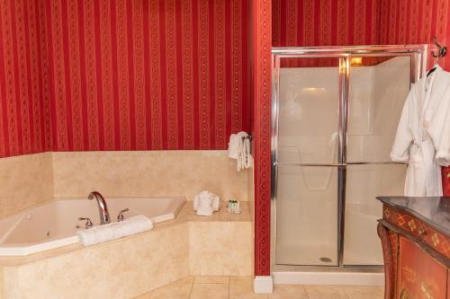 a bathroom with a tub and a shower with red walls at Antrim 1844 in Taneytown