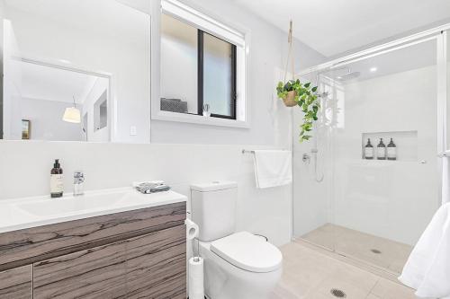 Baño blanco con aseo y lavamanos en Mala Retreat, Shiraz Suite 5 Star Immaculate and Comfortable, en East Maitland